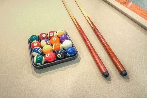 a bunch of billiard balls in a box next to two sticks